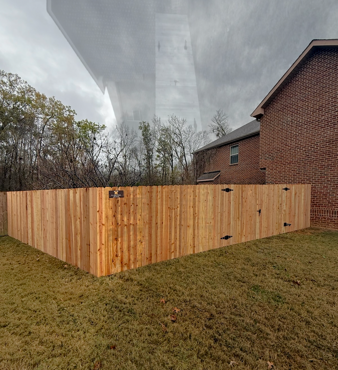A wooden fence is sitting on top of a lush green field.